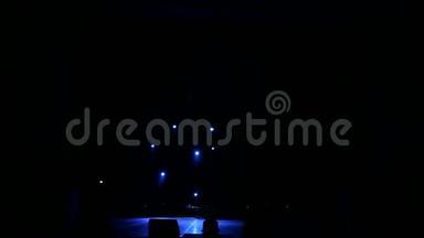 蓝色的光线在黑暗中交替地在舞台上闪现。 空的音乐会舞台。